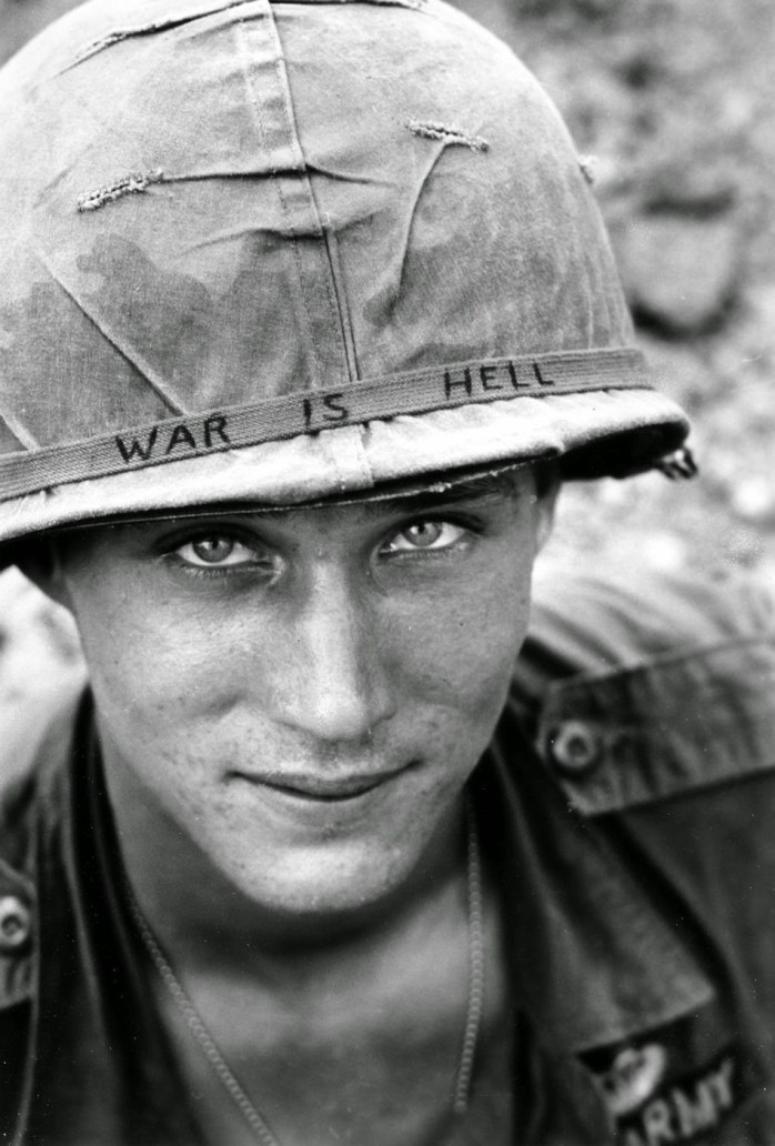 An American soldier wears a hand lettered War Is Hell slogan on his helmet, Vietnam, 1965